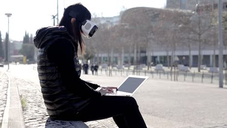 Young-woman-in-VR-headset-using-laptop
